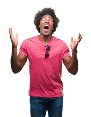 Afro american man over isolated background celebrating mad and crazy for success with arms raised...
