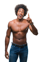 Fototapeta premium Afro american shirtless man showing nude body over isolated background pointing finger up with successful idea. Exited and happy. Number one.