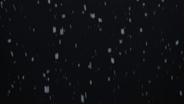 Real filmed snowfall against a black background as an overlay video. Real time. Endless loop.