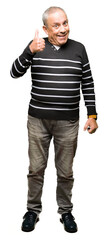Handsome senior man wearing winter stripes sweater doing happy thumbs up gesture with hand. Approving expression looking at the camera with showing success.