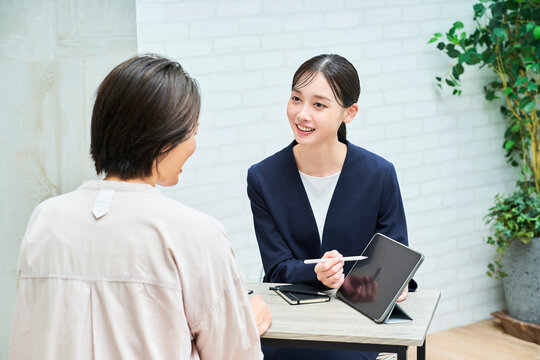 私服の女性に説明するスーツ姿の女性