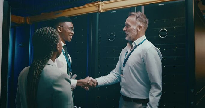 Business people, handshake and sever room for success, onboarding and cyber security agreement or programming. Professional technician shaking hands for congratulations or welcome in data center