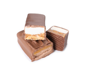 Pieces of tasty chocolate bars with nougat and nuts on white background
