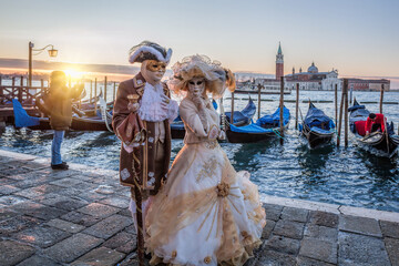 Colorful carnival masks at a traditional festival in Venice against gondolas, Italy