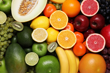 Many different fresh fruits and grapes as background, top view