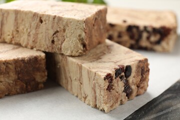 Pieces of tasty chocolate halva on table, closeup