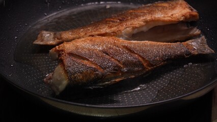 Crispy Seared Fish in Non-Stick Pan. Close-up, shallow dof.