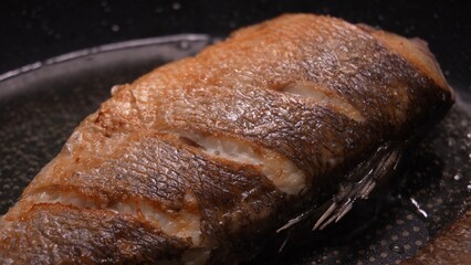 Crispy Seared Fish in Pan. Close-up, shallow dof.