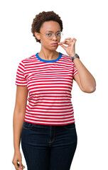 Beautiful young african american woman wearing glasses over isolated background mouth and lips shut...