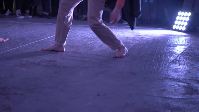 Contemporary or modern choreography. Women dancing barefoot on the concrete floor. Theatrical production of an art house about a modern fast fashion. Bare feet on the cold floor.