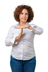 Beautiful middle ager senior businees woman over isolated background Doing time out gesture with...