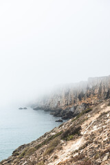 Dramatic cliffs in fog at Atlantic Ocean, Sagres, Algarve, Portugal