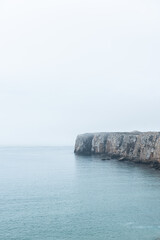 Dramatic cliffs in fog at Atlantic Ocean, Sagres, Algarve, Portugal