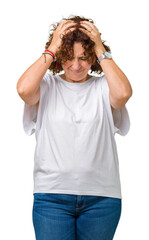 Beautiful middle ager senior woman wearing white t-shirt over isolated background suffering from headache desperate and stressed because pain and migraine. Hands on head.