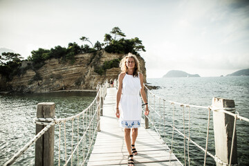 wooden footbridge leading to the small island of Agios Sostis on Zakynthos, Greece, during a sunny...
