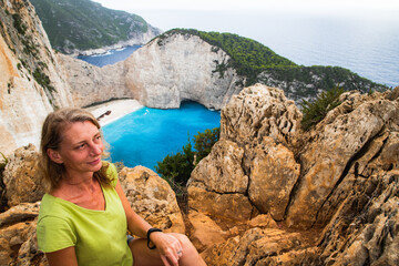 woman looking at Navagio beach with the famous wrecked ship in Zante  Greece