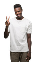 Young african american man wearing white t-shirt showing and pointing up with fingers number two while smiling confident and happy.