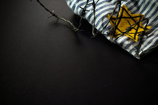 Jewish prisoner with yellow badge on dark background. International Holocaust Remembrance Day