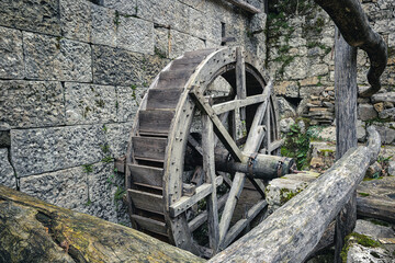 Obraz premium Wooden wheel of an antique water mill. Italian rural architecture, Stremiz village, Faedis, Udine province, Friuli Venezia Giulia, Italy.