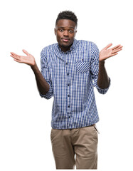 Young african american man wearing blue shirt clueless and confused expression with arms and hands...
