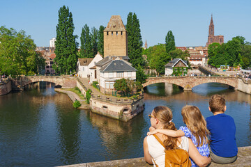A family of tourists looks on Bridge Ponts Couverts de Strasbourg, Strasbourg, Alsace, France....
