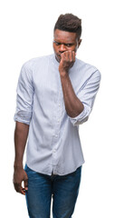 Young african american man over isolated background looking stressed and nervous with hands on mouth biting nails. Anxiety problem.