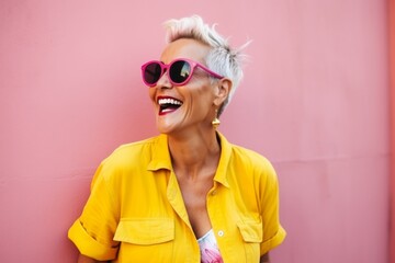 Close up portrait of a happy young woman in sunglasses against pink background