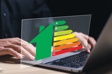 Energy efficiency concept. Person use laptop with virtual screen of energy efficiency rating for...