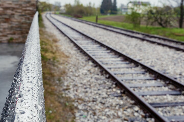 Train tracks in Radenci with some rain water droplets on the railing
