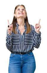 Middle age mature business woman over isolated background amazed and surprised looking up and pointing with fingers and raised arms.