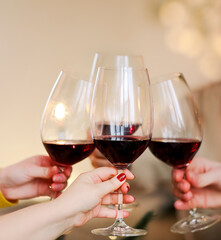 Crop friends clinking glasses of wine