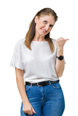 Middle age mature beautiful woman over isolated background smiling with happy face looking and pointing to the side with thumb up.