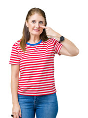 Middle age mature woman wearing casual t-shirt over isolated background Pointing with hand finger to face and nose, smiling cheerful