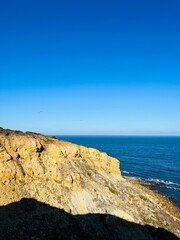 Ocean coast, clear blue sky, blue horizon, natural colors, no people