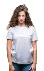 Beautiful brunette curly hair young girl wearing casual t-shirt over isolated background skeptic and nervous, frowning upset because of problem. Negative person.