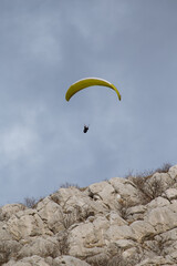 Paraglider flying over the sea coast in blue sky background