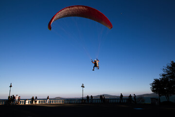 Paraglider flying over the sea coast in blue sky background