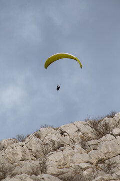 Paraglider flying over the sea coast in blue sky background