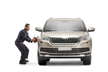Full length profile shot of a worker using an auto polisher for a SUV