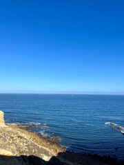 Ocean coast, clear blue sky, blue horizon, natural colors, no people