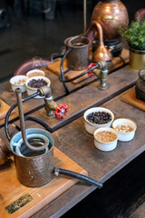 Small copper stills and distilling equipment arranged on a decorated table.