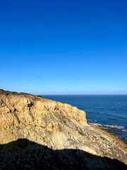 Ocean coast, clear blue sky, blue horizon, natural colors, no people