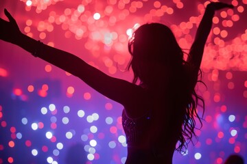 Silhouette of a woman dancing at a concert with vibrant stage lights in the background.
