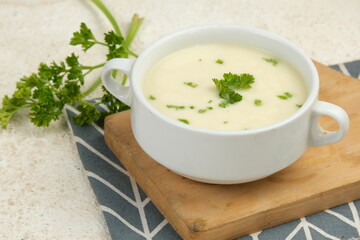 Bowl of cream soup on white table