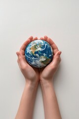 A pair of open palms on a white background, gently lulling a lonely model of planet earth