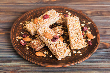 Various granola bars on table background. Cereal granola bars. Superfood breakfast bars with oats, nuts and berries, close up. Superfood concept