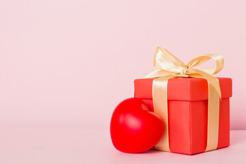 gift box with red bow and red heart on colored background. Perspective view. Flat lay