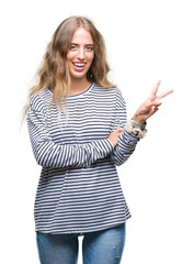 Beautiful young blonde woman wearing stripes sweater over isolated background smiling with happy face winking at the camera doing victory sign. Number two.