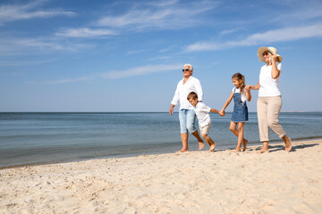 Cute little children with grandparents spending time together on sea beach