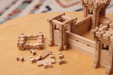 Wooden fortress and building blocks on table indoors. Children's toy